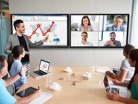 two screens on the wall of a conference room