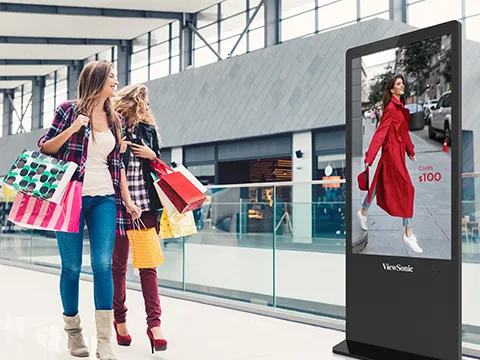 two women walking past a kiosk in a mall