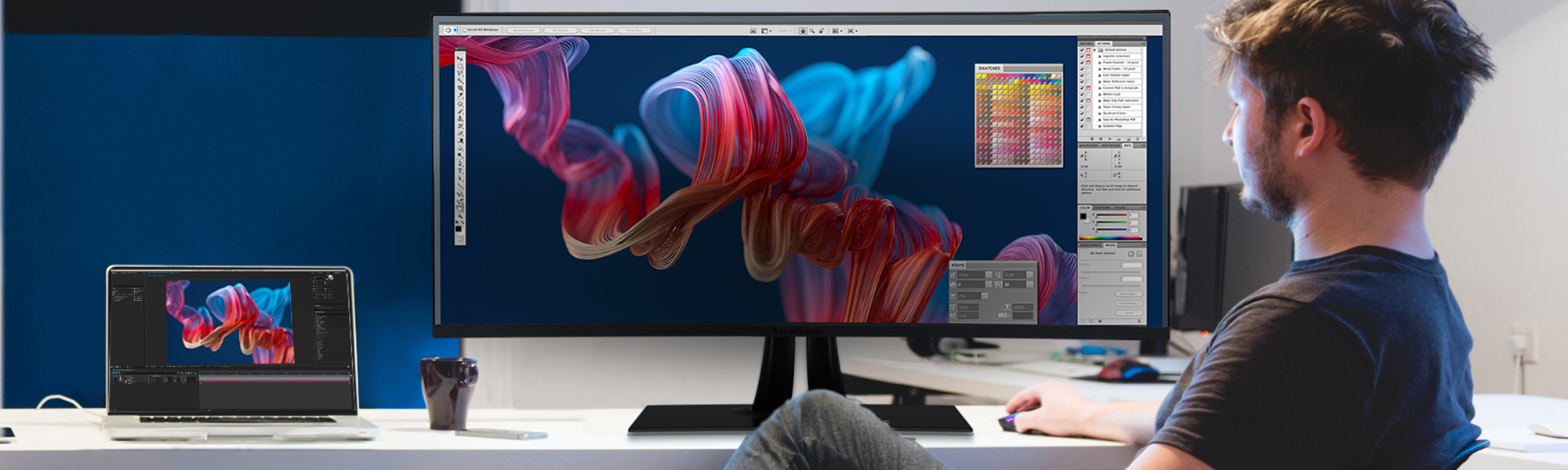 a man uses graphic design software on an ultrawide monitor