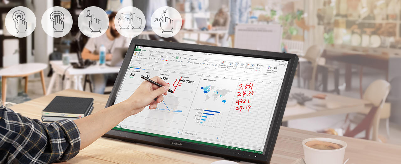 a woman using an ultrawide monitor with multiple windows open while taking notes in a notebook