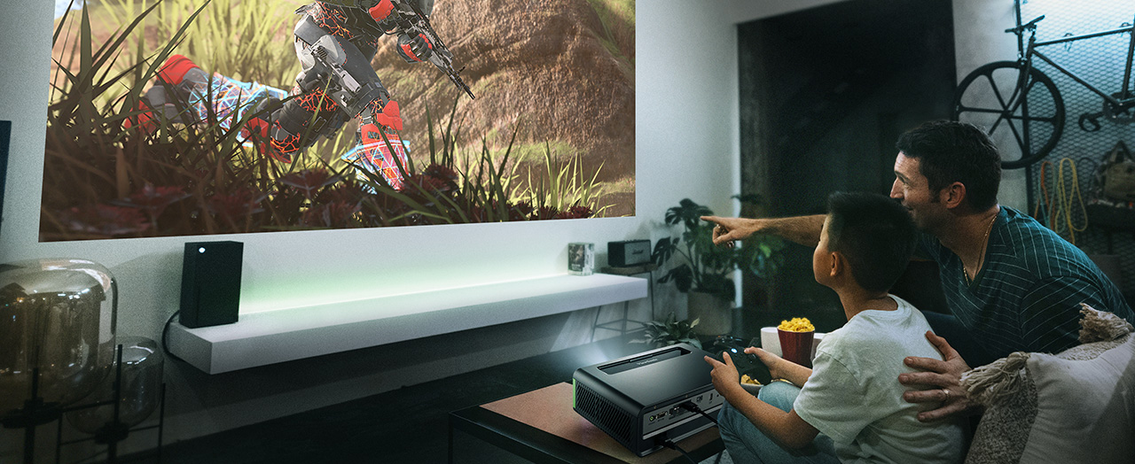 Father and son on a couch playing a video game from an Xbox
