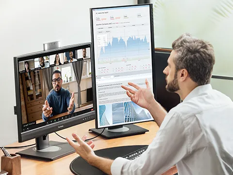 a man on a video call with a grap on a portrait orientation display to the side