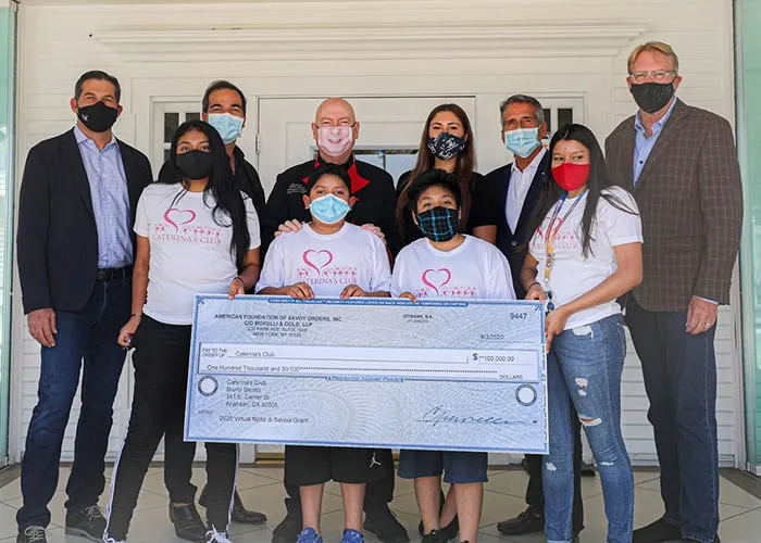 a group of people holding up a giant check