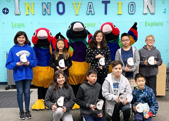 a group of children posing with people in finch costumes while holding awards
