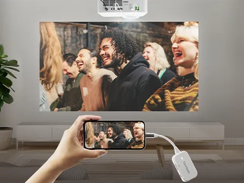 a wireless dongle connected to a smartphone casting to a projector.